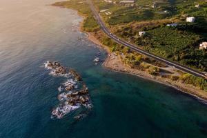 aéreo.estrada e ondas flutuam para a costa rochosa. foto