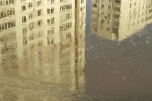 edifício é refletido na poça. superfície da água na cidade. foto