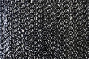 material de embalagem de bolha de ar de filme plástico na textura de sobreposição de fundo preto foto