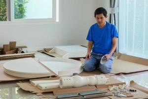 homem montando móveis de mesa redonda branca em casa foto
