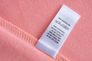 etiqueta de roupas de lavagem de cuidados com a roupa branca na camisa de algodão rosa foto
