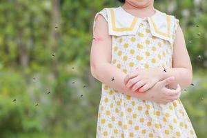 menina tem alergia de erupção cutânea comichão e coçando no braço com picada de mosquito foto