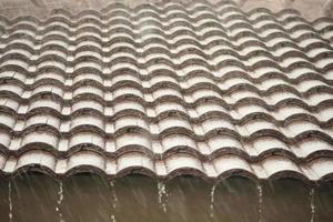 chuva caindo do telhado da casa foto