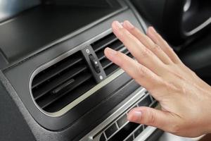 mão verificando o sistema de ar condicionado dentro do carro foto