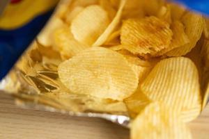 batatas fritas crocantes em saco de lanche na mesa de madeira foto