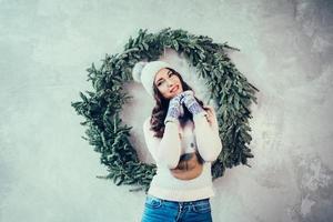 mulher em roupas quentes na árvore de natal foto