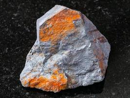 minério de hematita bruto em granito preto foto