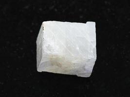 pedra de calcita branca áspera em fundo escuro foto