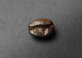 grão de café torrado em fundo preto foto