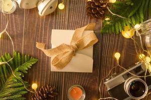 luzes de natal bokeh em casa em enfeites de mesa de madeira. decoração de férias de inverno, conceito de decorações de natal e ano novo foto