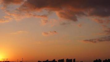 a bela vista do pôr do sol com as nuvens coloridas e o céu da cidade foto