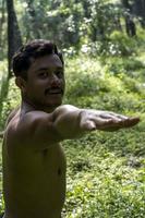 homem visto de perto, sem camisa fazendo alongamentos no tapete de ioga, exercício, américa latina foto