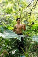 homem visto de perto, sem camisa fazendo alongamentos no tapete de ioga, exercício, américa latina foto