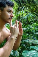 homem visto de perto, sem camisa fazendo alongamentos no tapete de ioga, exercício, américa latina foto