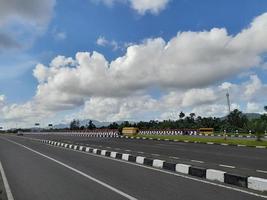 rodovia com fundo de céu azul com poucas nuvens foto