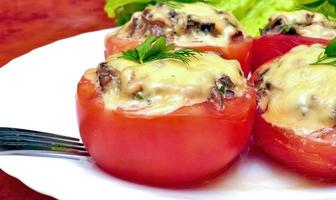 tomates frescos recheados com cogumelos, cebola e queijo assados no forno. foto