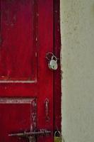 fechado cadeado na porta rústica velha vermelha foto