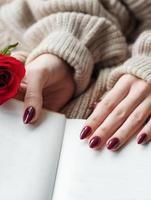 mãos de uma jovem com manicure vermelho escuro nas unhas foto