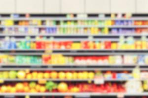 corredores de supermercado de fundo desfocado abstrato com prateleiras coloridas de mercadorias. foto