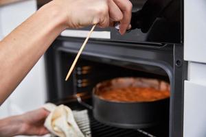 dona de casa preparar bolo na cozinha. bolo caseiro assando no forno foto