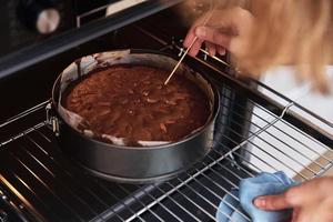 dona de casa preparar bolo na cozinha. bolo caseiro assando no forno foto