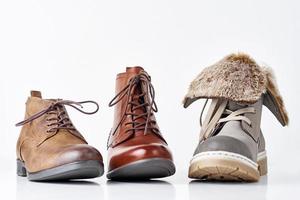 três botas femininas de couro diferentes no fundo branco isolado foto