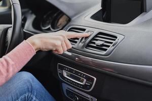 mão de mulher pressione o botão de parada de emergência no carro foto