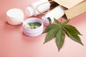 conjunto cosmético de cuidados com a pele e folha verde de maconha foto