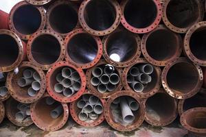 um fundo industrial de textura de pilha de tubos de ferro enferrujado foto
