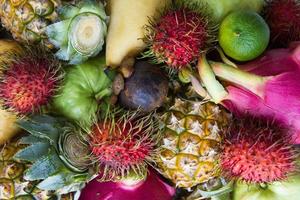 closeup de frutas coloridas frescas misturadas. fruta do dragão, abacaxi, limão, manga, rambutan, mangostão, goiaba. foto