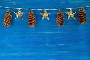 decorações de natal com cones no fundo azul de madeira, vista superior. foto