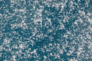 flocos de neve em um fundo azul. textura de neve closeup, fundo natural de natal foto