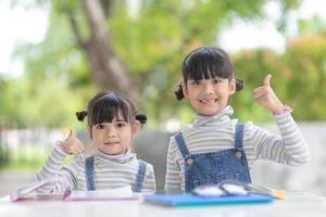 duas estudantes meninas asiáticas lendo o livro na mesa foto