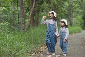 as crianças estão indo para o acampamento da família na floresta caminhar ao longo da rota turística. estrada de acampamento. conceito de férias de viagem em família. foto