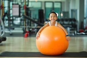 menino criança asiática com bola de ginástica foto