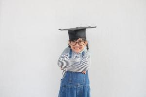 feliz garoto da escola asiática graduado no boné de formatura foto