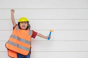 garota asiática vestindo camisas reflexivas e um chapéu amarelo. para aprender e potencializar o desenvolvimento, pequeno arquiteto. foto