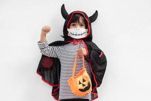 menina asiática em uma fantasia de halloween em uma máscara médica. dia das bruxas com medidas de segurança do covid-19 foto