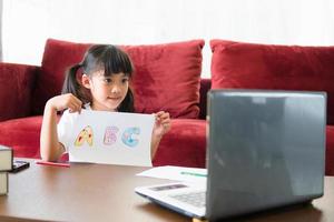 Aluna asiática Aula de aprendizagem on-line estuda on-line com laptop em casa. foto