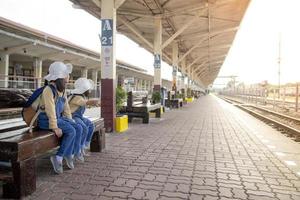 duas garotas em uma estação ferroviária, esperando o trem foto