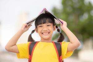 menina bonita a menina está feliz com o livro foto