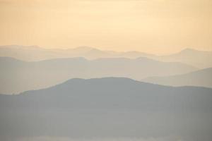 camada de montanhas e névoa durante o pôr do sol foto