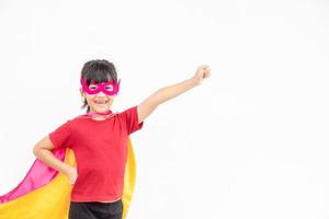 menina engraçada jogando super-herói de poder sobre fundo branco. conceito de super-herói. foto