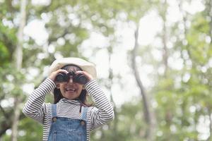 criança feliz olhando para frente. criança sorridente com os binóculos. conceito de viagens e aventura. liberdade, férias foto