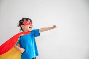 conceito de crianças, menina sorridente jogando super-herói em fundo branco foto