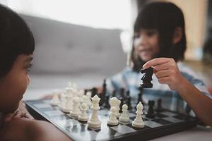 irmãzinha jogando xadrez em casa. foto