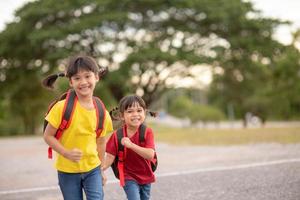 bonitos crianças asiáticas de mãos dadas enquanto vão para a escola foto