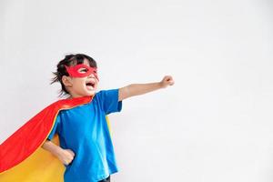 menina engraçada jogando super-herói de poder sobre fundo branco. conceito de super-herói. foto