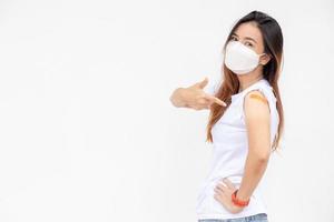 mulheres asiáticas mostram curativo no braço. feliz mulher asiática se sente bem depois de receber a vacina em fundo branco. foto