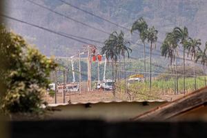 funcionários da empresa elétrica realizando reparos em postes foto